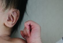 Baby with ear and hand