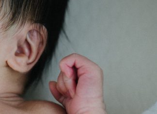 Baby with ear and hand