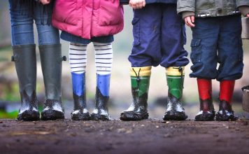 4 kids with rainboots on in mud