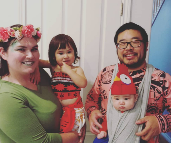 Family dressed as characters from Moana: Te fiti (mom), Moana (daughter), Maui (Dad), Hei Hei (baby son)