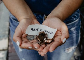 image depicting donations via a woman holding her hands out with coins and a piece of paper that says make a change