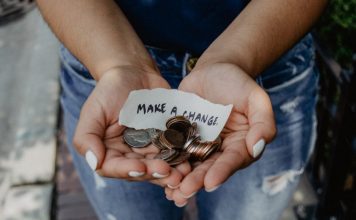 image depicting donations via a woman holding her hands out with coins and a piece of paper that says make a change