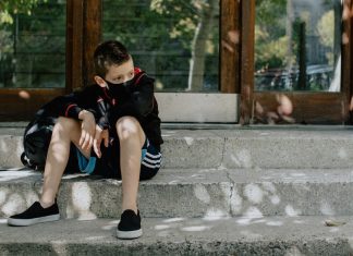 Kid sitting on steps outside of school