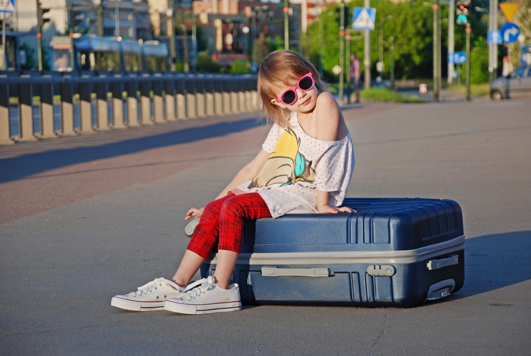 child sitting on a suitcase