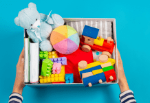 A box of kids toys held out by child's hands.