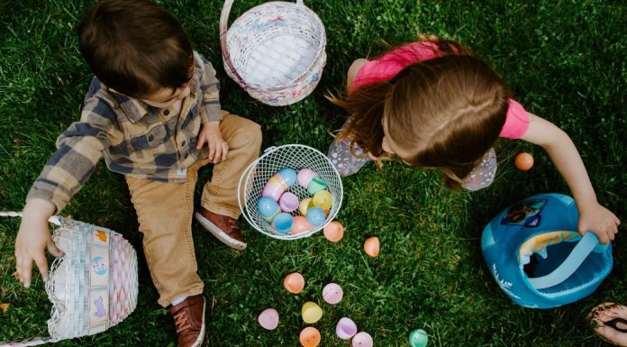 Two kids collect Easter eggs on the grass