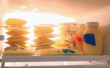 freezer with bags and bottles of frozen breastmilk