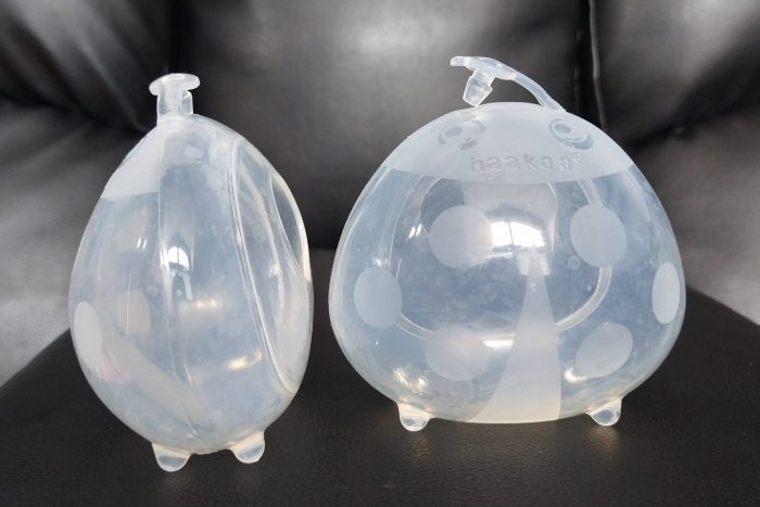 Two Haakaa ladybug passive breastmilk collection cups in frontal and side view