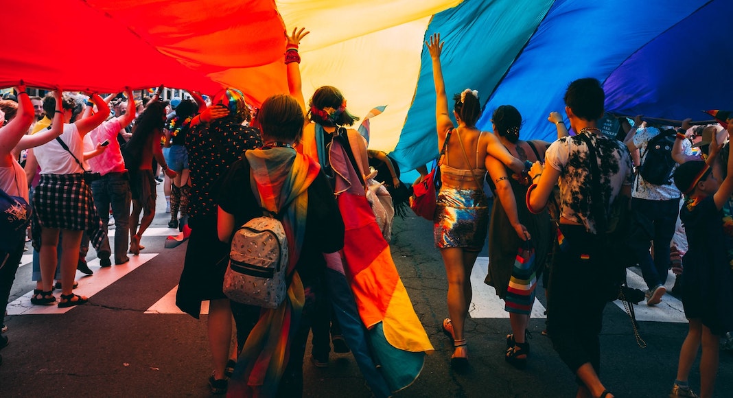Pride Festival Flag with people dancing under it