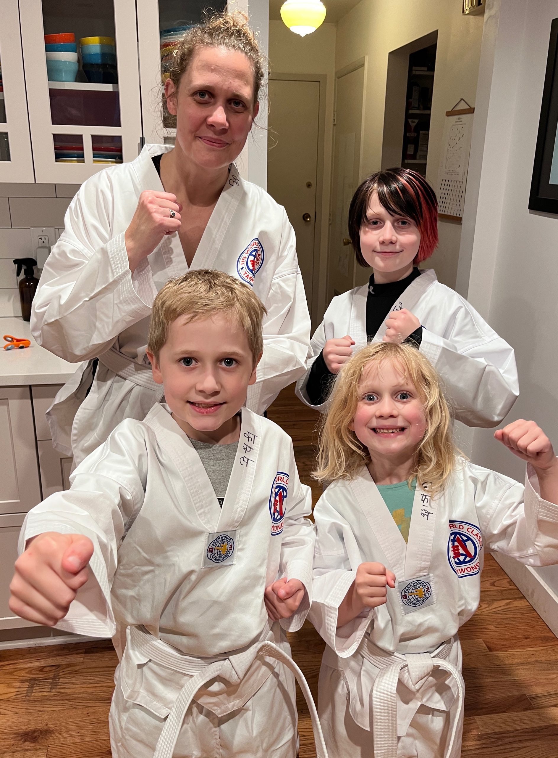 Family poses for picture before Taekwondo class in white belts