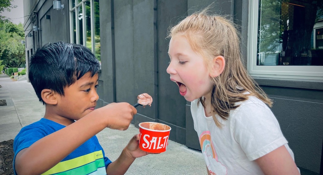 Boy feeding girl ice cream