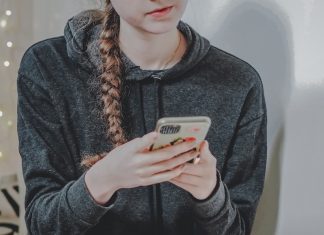 Teenager looks at her phone in a room