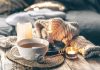 Image of hygge-inspired cozy tea setting with candles and blankets.